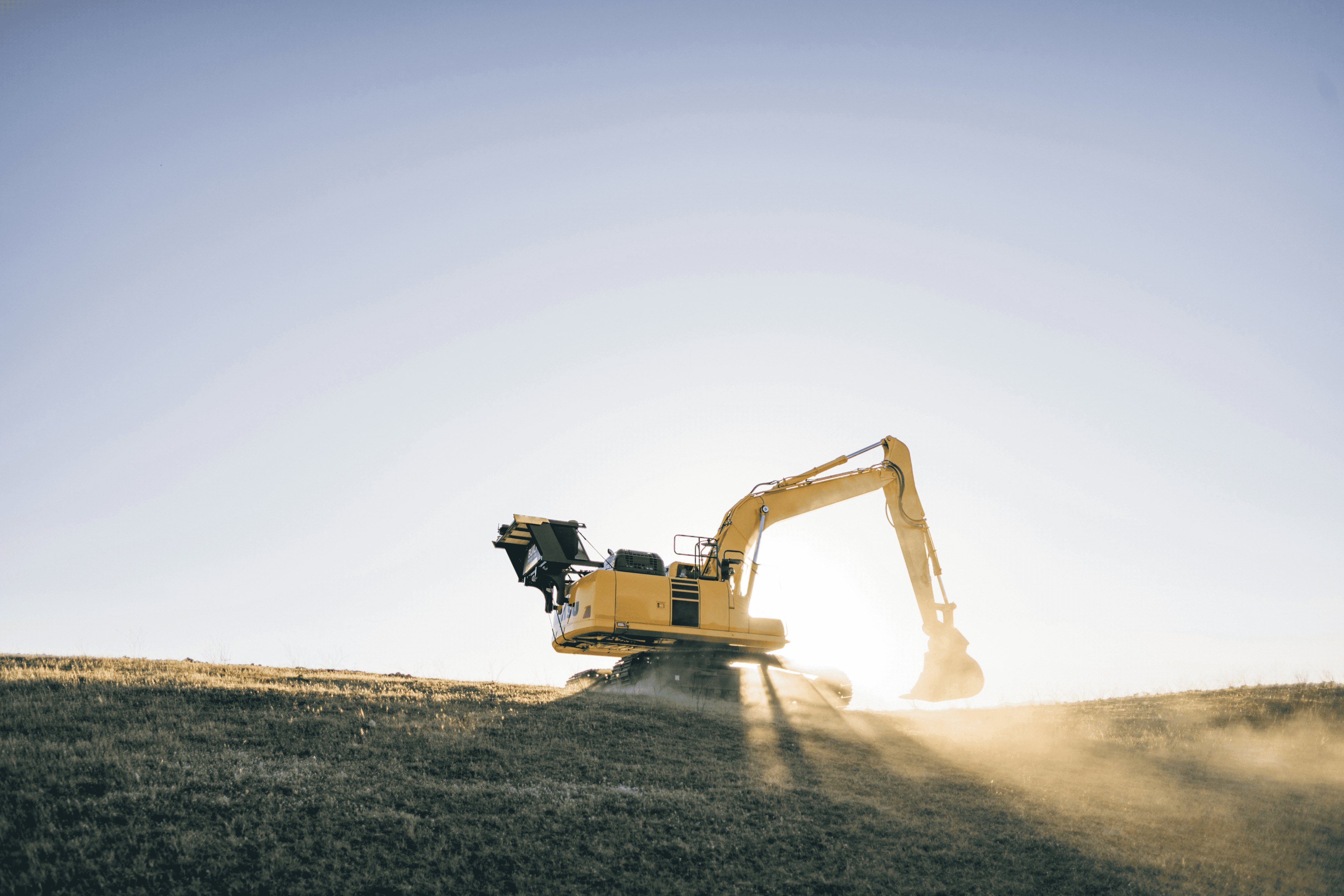 Construction excavator at work during sunset
